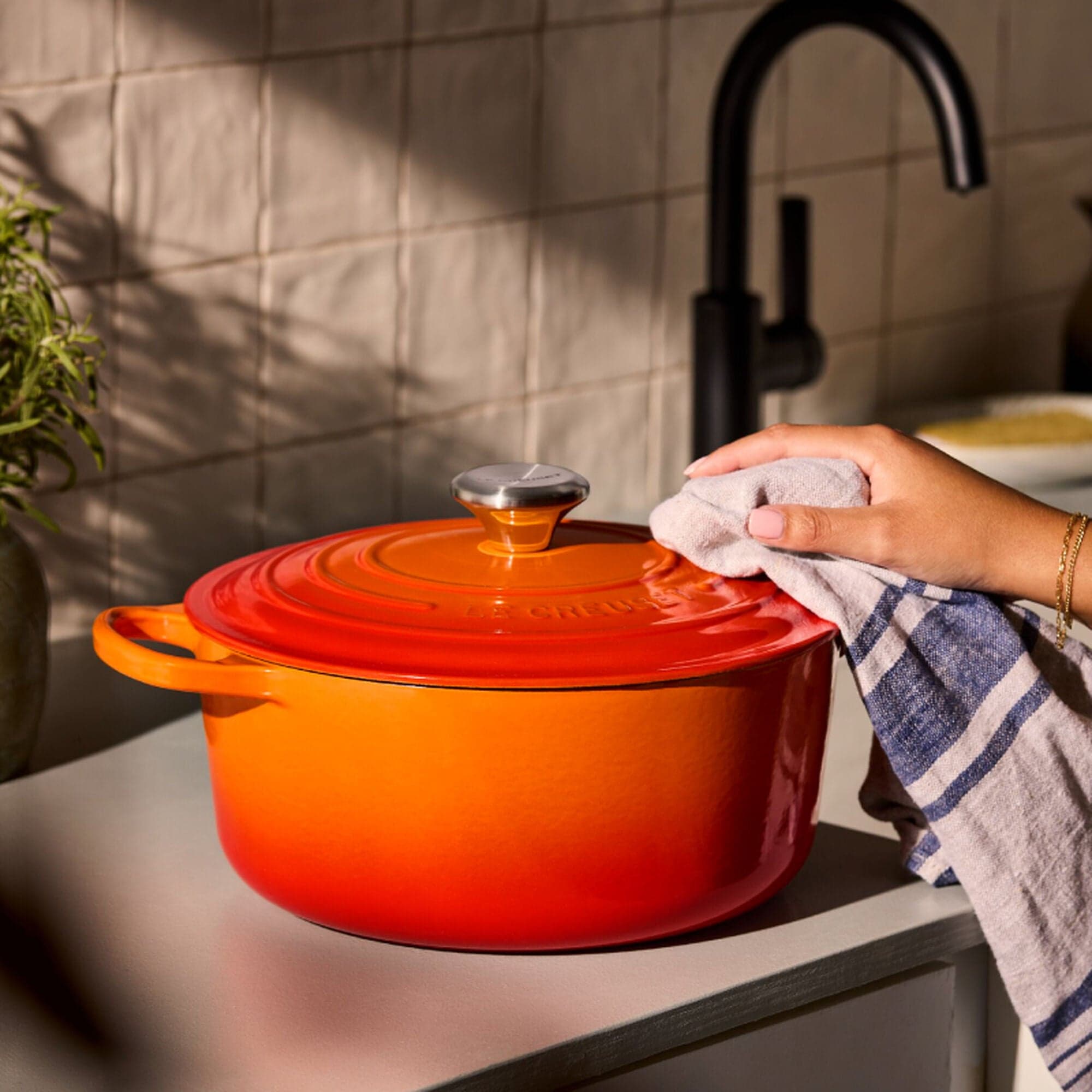 Flame orange Le Creuset Signature round Dutch oven with the lid on